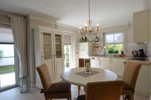 a kitchen with a table and chairs and a chandelier at Strandperle 9, PP außen in Zingst