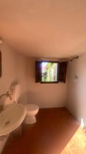 uma casa de banho com um WC, um lavatório e uma janela em The Simple Life em Casoli