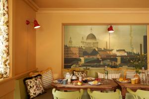 ein Esszimmer mit einem Tisch, Stühlen und einem Gemälde in der Unterkunft Hotel De Londres in Brig