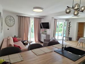 a living room with a couch and a table at Luxury Kvarner Park Villa with garden and large RGB private pool in Kastav