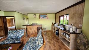 a living room with two couches and a kitchen at Lianita's Cottage (Selfcatering) in La Digue