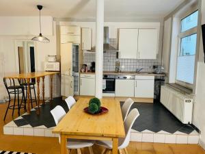 Una cocina con una mesa de madera y gabinetes blancos. en Edu Home Bremen, en Bremen