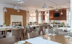 a restaurant with tables and chairs and a fireplace at Mercure Wiazowna Brant in Wiązowna