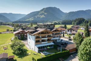 une vue aérienne sur un village avec des montagnes en arrière-plan dans l'établissement Hotel Waidachhof, à Kössen
