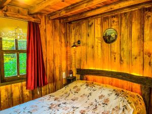 a bedroom with a bed in a wooden wall at Kaf Dagi Konak Hotel in Rize