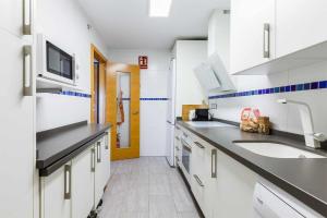 een keuken met witte kasten en een spoelbak bij A&N La Vega 13 in Torre del Mar