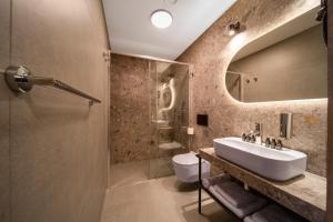 uma casa de banho com um lavatório, um chuveiro e um WC. em Hotel Alexander na Cracóvia