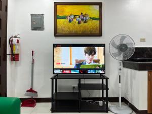a flat screen tv sitting on a stand in a living room at HRS APARTELLE in Talisay