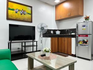 a living room with a tv and a table at HRS APARTELLE in Talisay