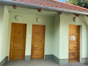two wooden doors on the side of a house at Nomád jurta Zalakaros mellett in Zalamerenye