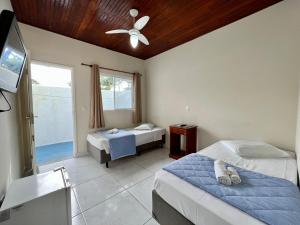 a bedroom with two beds and a ceiling fan at Pousada Albamar Guarujá in Guarujá