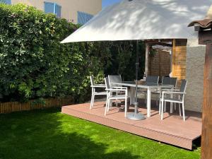 een houten terras met een tafel en stoelen onder een parasol bij Villa Harmonie - unique provençal charm in Antibes