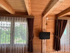 a room with a tv on the wall next to a window at Abduloğlu Butik Otel in Ayder Yaylasi