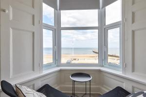 a room with a window with a view of the beach at 5 Roker Terrace - Seaview apartments in Sunderland