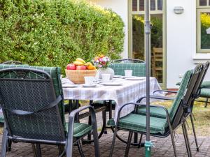 an outdoor table with chairs and a bowl of fruit at Ferienhaussiedlung Strandperlen Buchenhof 2b (Typ VI) in Wustrow