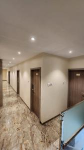 a hallway of a building with doors and marble floors at Peace International in Mumbai