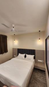 a bedroom with a large white bed with two pillows at Peace International in Mumbai