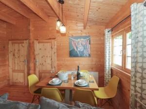 een houten eetkamer met een tafel en stoelen bij Pigsfoot Lodge in Tiverton