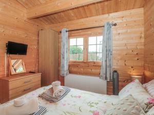 a bedroom with a bed and a window at Pigsfoot Lodge in Tiverton