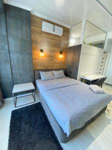 - une chambre avec un grand lit et un miroir dans l'établissement Ultracentral Lux Apartment, à Chişinău