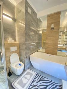 La salle de bains est pourvue d'une baignoire, de toilettes et d'un lavabo. dans l'établissement Ultracentral Lux Apartment, à Chişinău