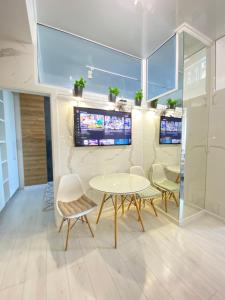 Cette chambre dispose d'une table, de chaises et d'une télévision. dans l'établissement Ultracentral Lux Apartment, à Chişinău