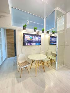 a room with a table and chairs and a tv at Ultracentral Lux Apartment in Chişinău