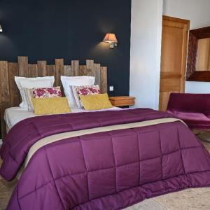 eine große lila Bettdecke auf einem Bett in einem Zimmer in der Unterkunft Chambres d'Hôtes Bianca Casa in Porto-Vecchio