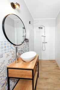 a bathroom with a sink and a mirror at Apartament Toskański in Rewal