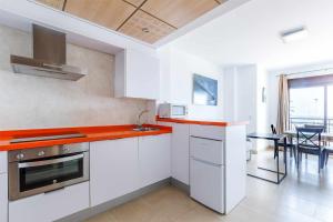 a kitchen with white cabinets and orange counter tops at A&N Seaport 1B in Caleta De Velez