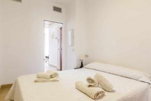 a white bedroom with a bed with towels on it at A&N Seaport 1B in Caleta De Velez