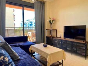 a living room with a blue couch and a flat screen tv at A&N Spacious Family Retreat with Pool & Parking in Torre del Mar