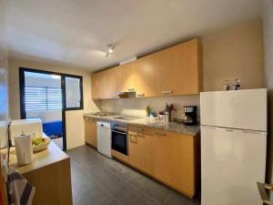 a kitchen with wooden cabinets and a white refrigerator at A&N Spacious Family Retreat with Pool & Parking in Torre del Mar