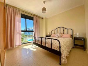 a bedroom with a bed and a large window at A&N Spacious Family Retreat with Pool & Parking in Torre del Mar
