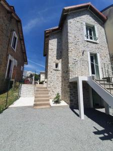 una casa de piedra con una escalera delante de ella en MAISON AMPERE, en Limoges