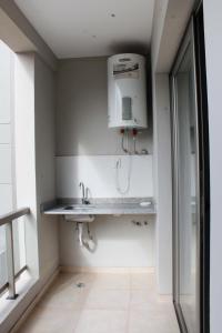 baño con lavabo y dispensador de agua en la pared en Departamento ALCLA I en Corrientes