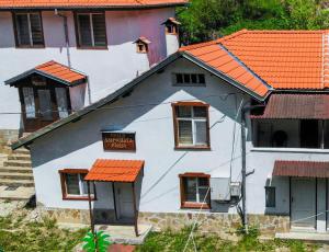 uma casa branca com um telhado laranja em Комплекс Петлето em Smolyan