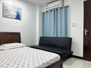 a small bedroom with a bed and a window at HRS APARTELLE in Talisay