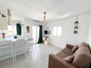 sala de estar blanca con sofá y cocina en Apartamentos Formentera Copacabana 18, en Es Pujols