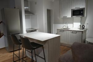 a kitchen with a counter and some chairs in it at Casa Margarita in Peñaranda de Duero +11 photos