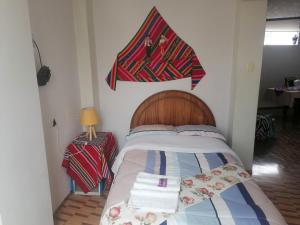 een slaapkamer met een bed met een vlag aan de muur bij Apartamento sombras del titicaca in Puno