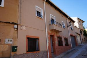 Edificio naranja con ventanas y balcón en Casa Margarita en Peñaranda de Duero