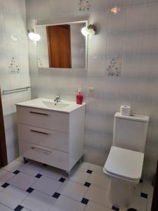 y baño con lavabo, aseo y espejo. en Casa Margarita en Peñaranda de Duero