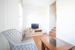 uma sala de estar com uma cadeira e uma televisão em Casa Playa Graña "Ferrol" em Ferrol