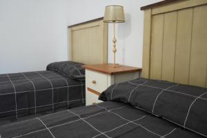 dos camas sentadas una al lado de la otra en una habitación en Casa Margarita en Peñaranda de Duero