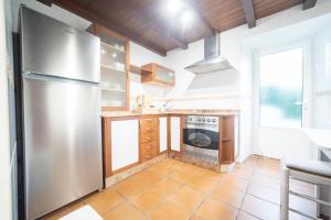 uma cozinha com um frigorífico de aço inoxidável e um fogão em Casa Playa Graña "Ferrol" em Ferrol