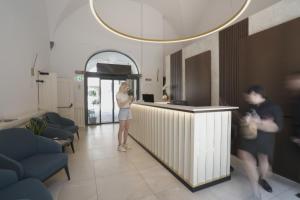 a woman standing at a counter in a room at Palazzo Santo Spirito in Bergamo