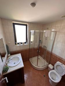 uma casa de banho com um chuveiro, um WC e um lavatório. em Nana apartment in Kaliakria resort em Topola