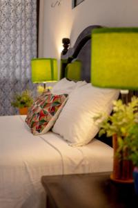 1 cama con almohadas blancas y cabecero verde en Casa Makech, en Valladolid