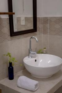 lavabo blanco en el baño con espejo en Casa Makech, en Valladolid